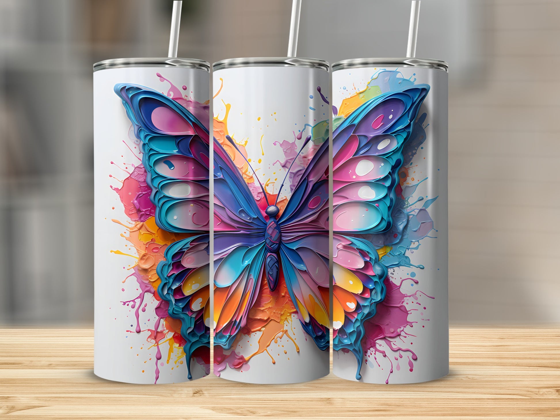 Three white tumblers with colorful butterfly and paint splash designs.