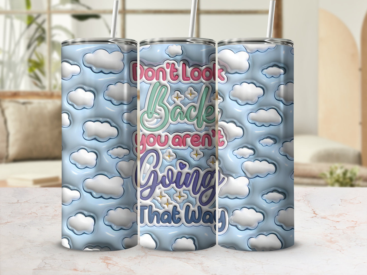 Don't Look Back You Aren't Going That Way text on a cloud patterned tumbler.