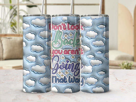 Don't Look Back You Aren't Going That Way text on a cloud patterned tumbler.
