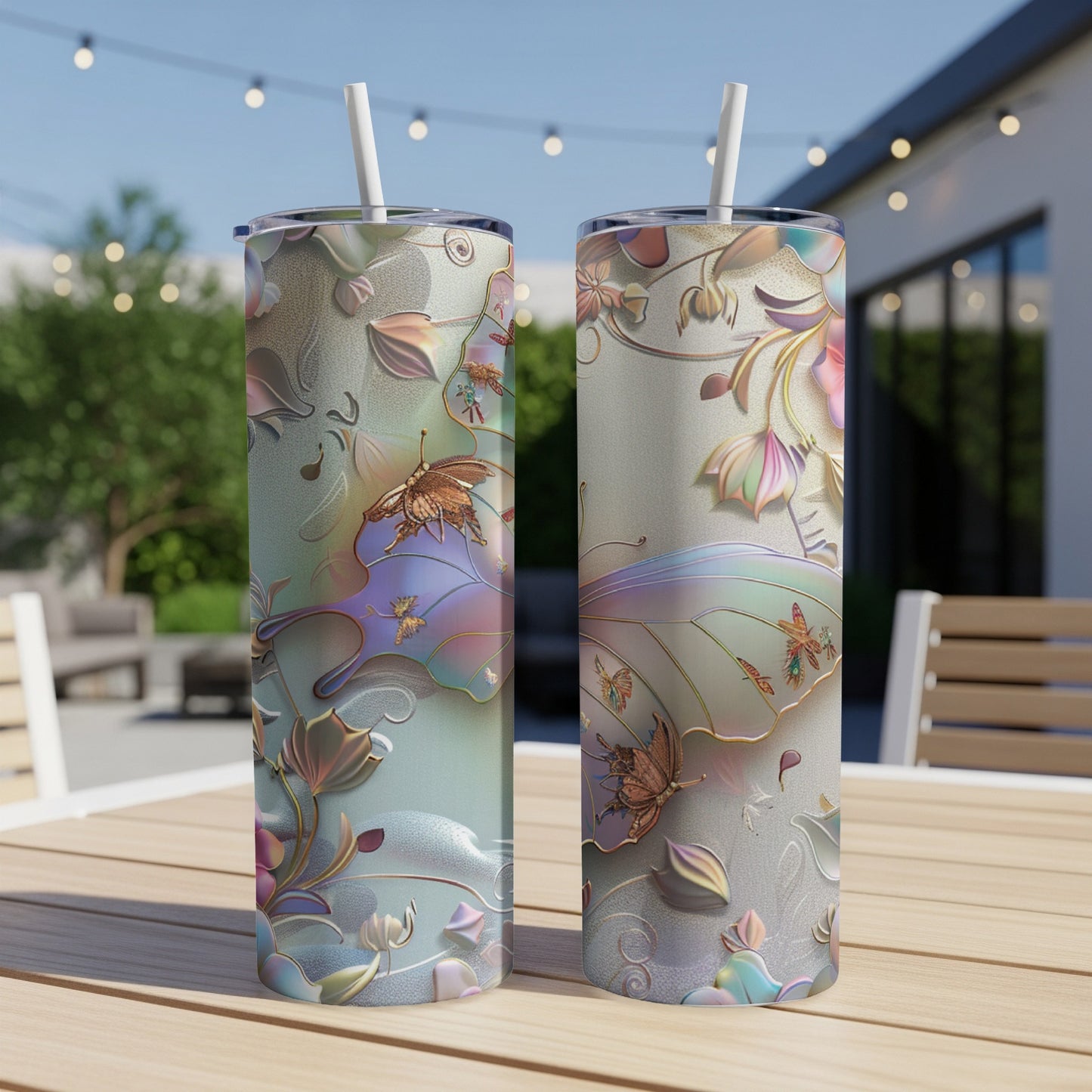Two tall tumblers with iridescent butterfly and floral designs on a table.