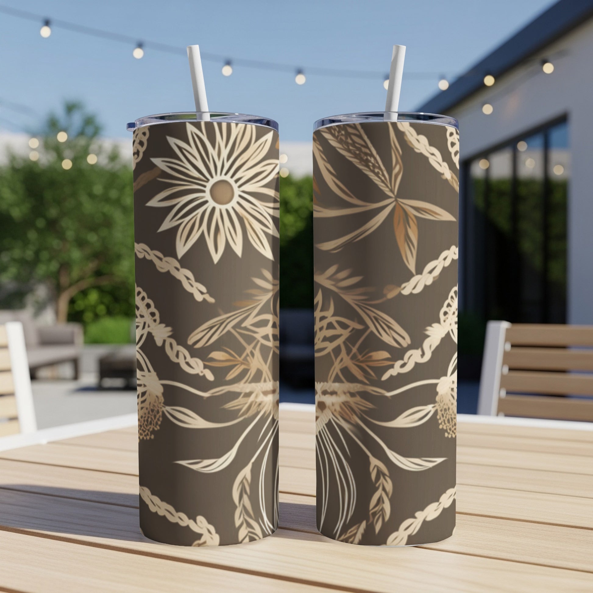 Two brown tumblers with floral and vine pattern on a wooden table.