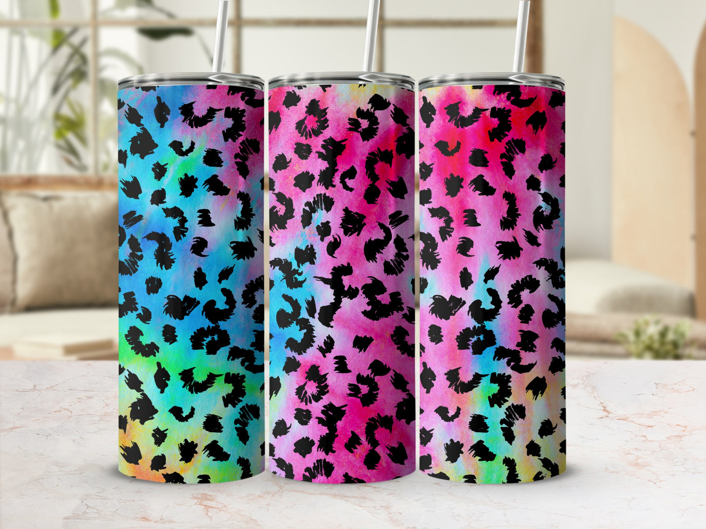 Three tumblers with black leopard print on colorful tie-dye backgrounds.