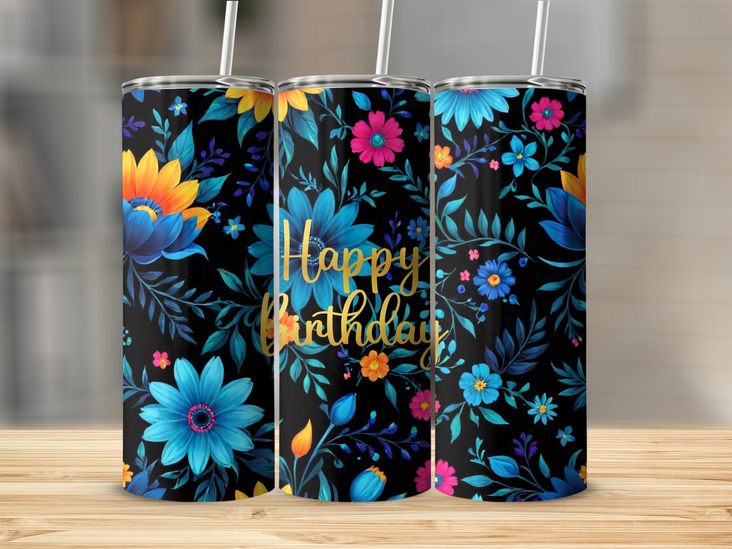 Three tumblers with "Happy Birthday" and floral designs on a wooden surface.