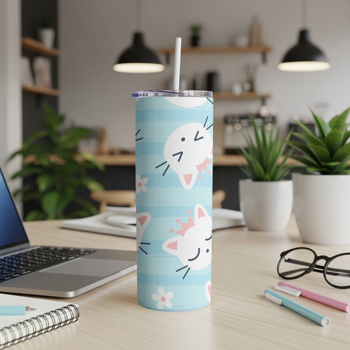 Blue tumbler with cartoon white cats wearing pink crowns and small white flowers.