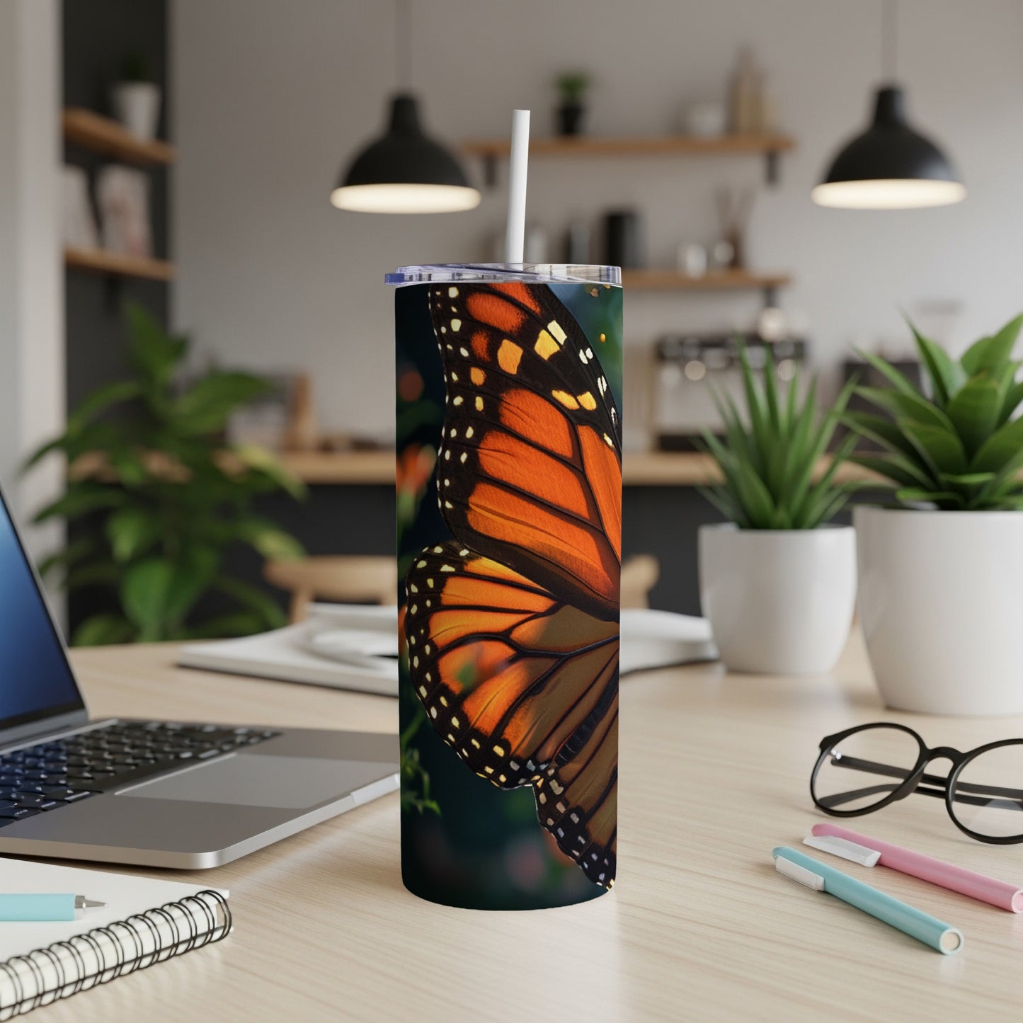 Monarch butterfly wing close-up on a tumbler, with blurred kitchen background.