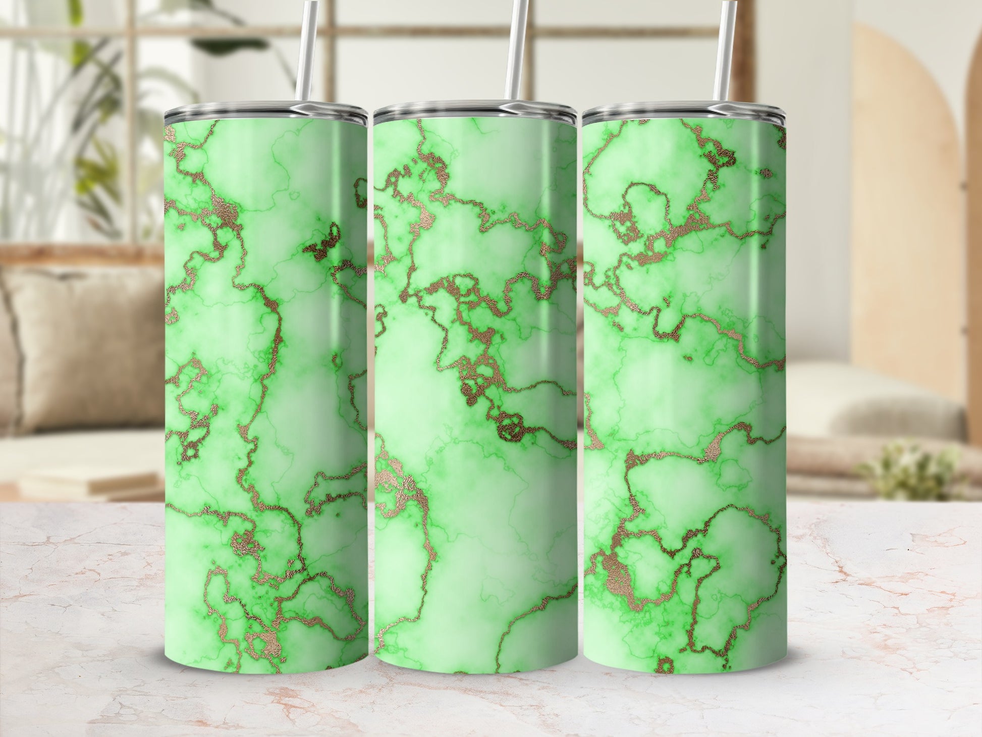 Three green marble tumblers with rose gold veining and straws.