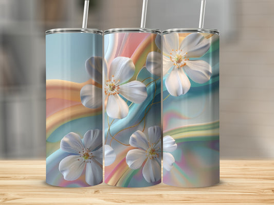 Three tumblers with floral and rainbow gradient designs on a wooden surface.