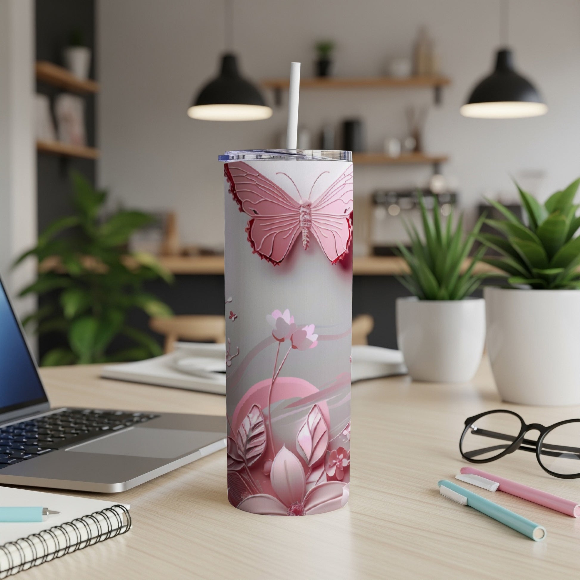 Pink butterfly design on a tall, insulated tumbler with a straw.