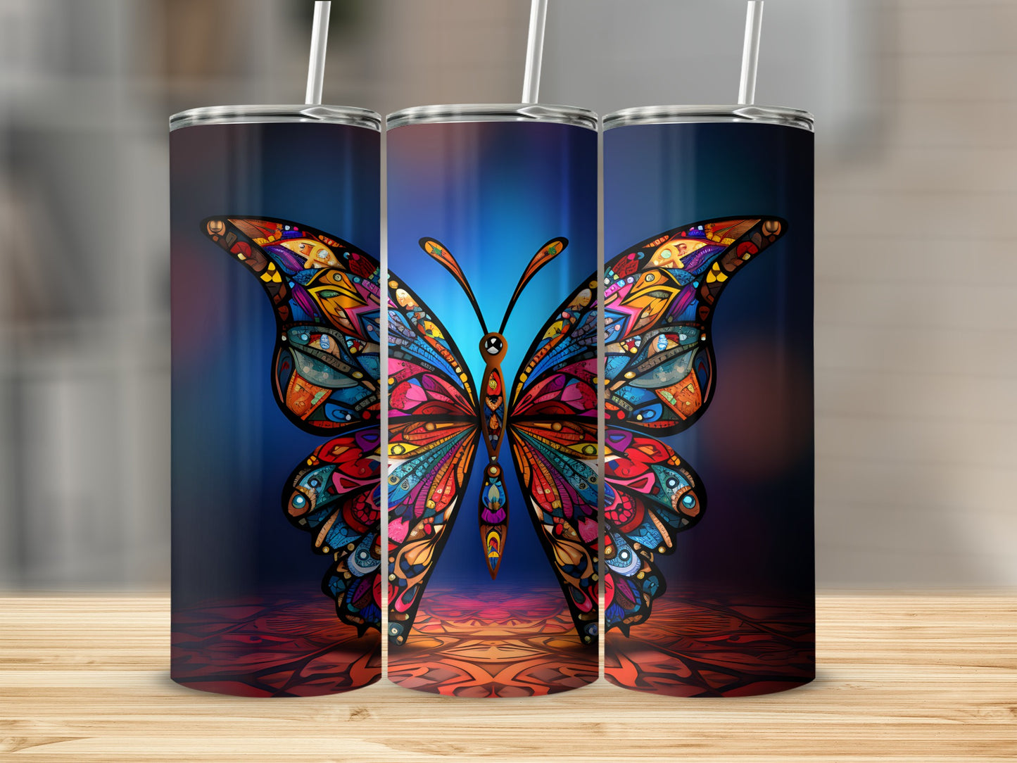 Three tumblers with colorful stained-glass butterfly designs on a wooden surface.