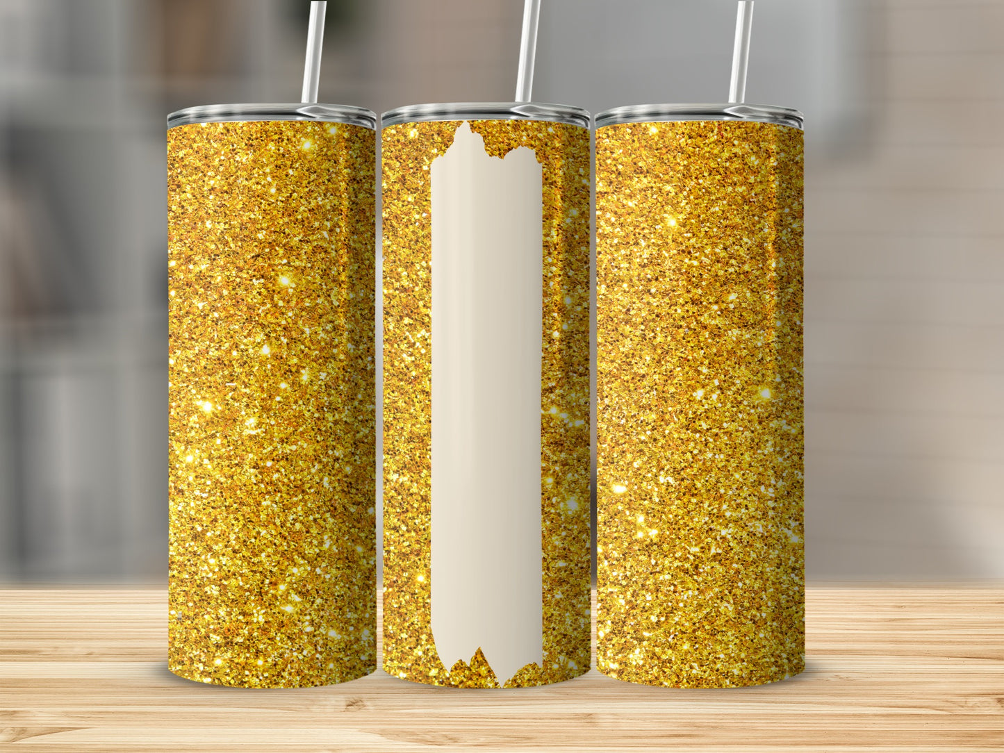 Three gold glitter tumblers with white stripes, displayed on a wooden surface.