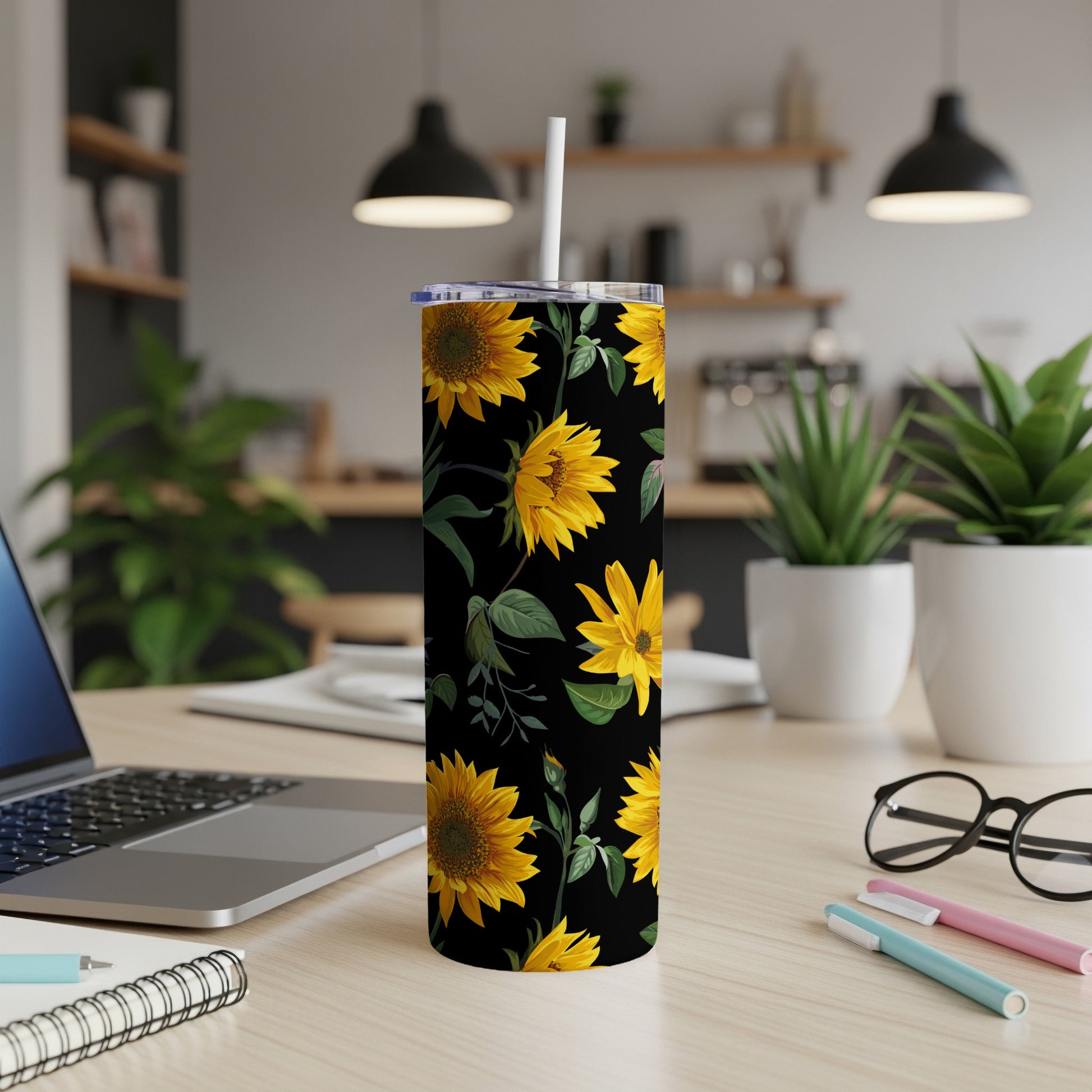 Black tumbler with a yellow sunflower pattern and a white straw.