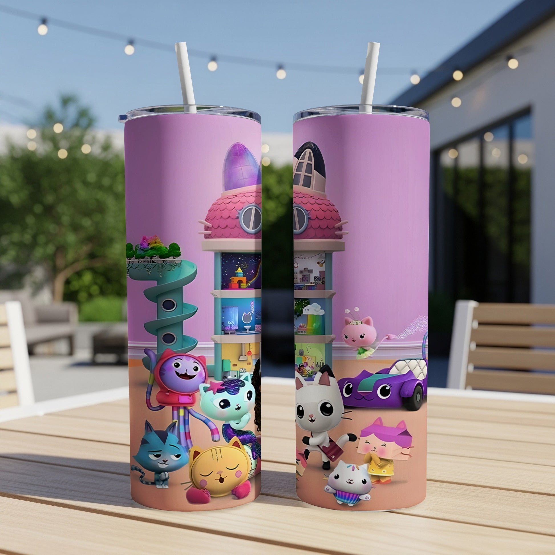 Gabby's Dollhouse characters on a pink tumbler with a straw, set on a table.