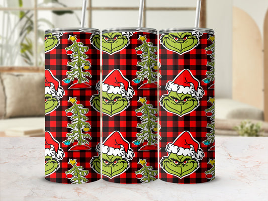 Three Grinch tumblers with Santa hats and Christmas trees on red plaid background.