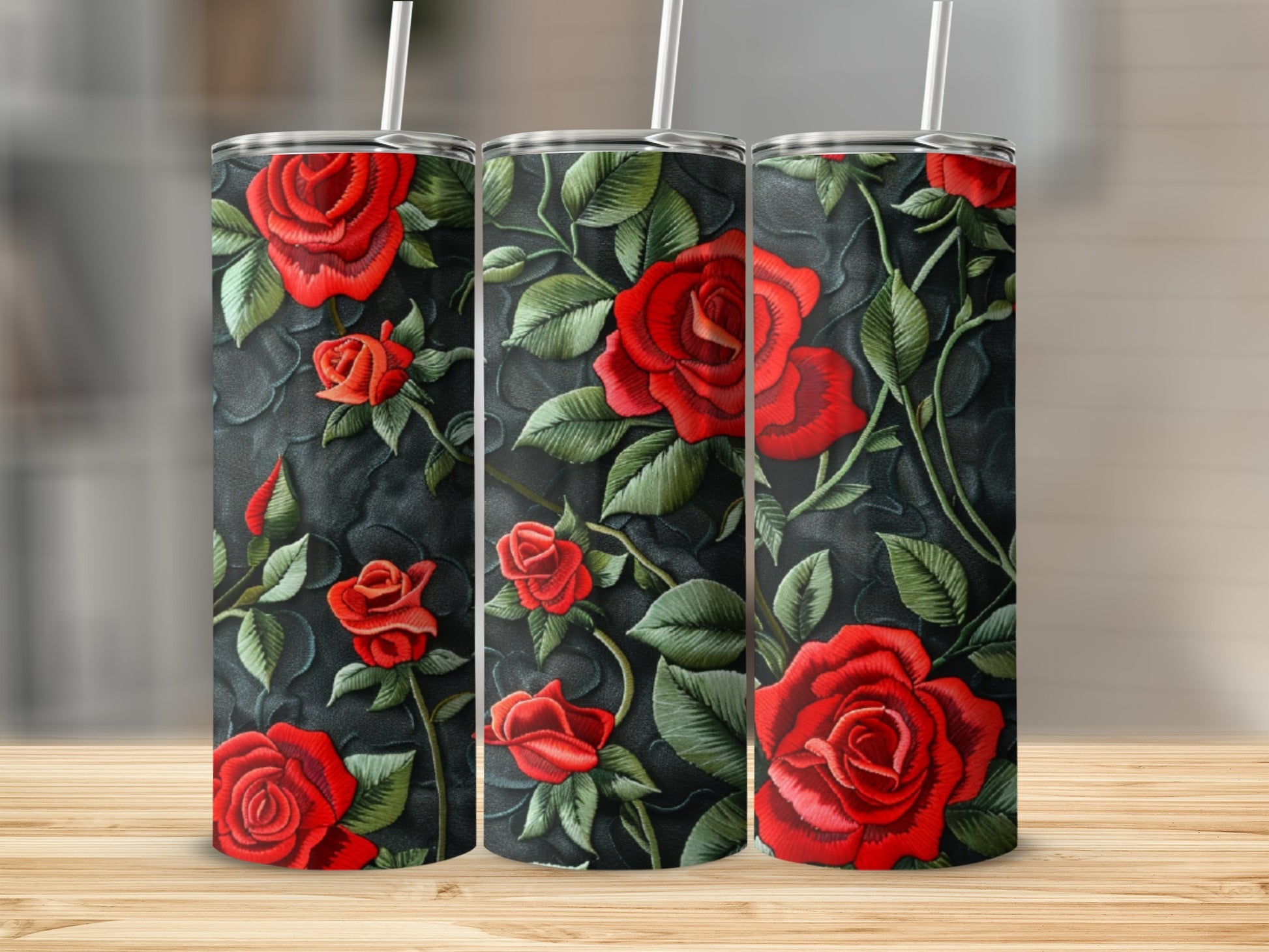 Three tumblers with a red rose floral design on a dark textured background.