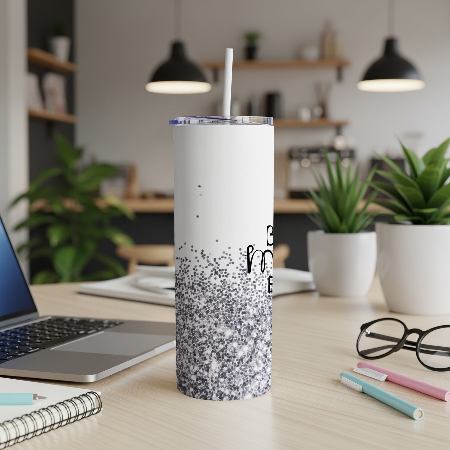 White tumbler with black text "mama" and glitter detail on desk.