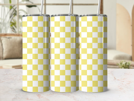 Three yellow and white checkered tumblers with straws on a marble surface.