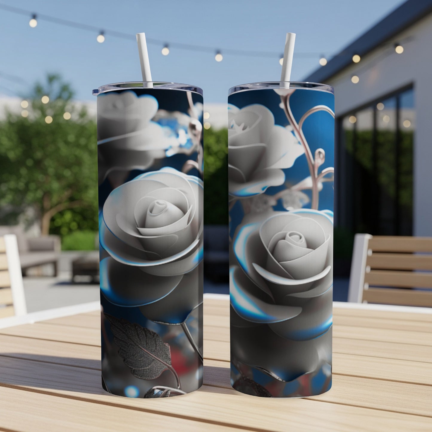 Two tall, slim tumblers with a detailed silver rose design on a table.