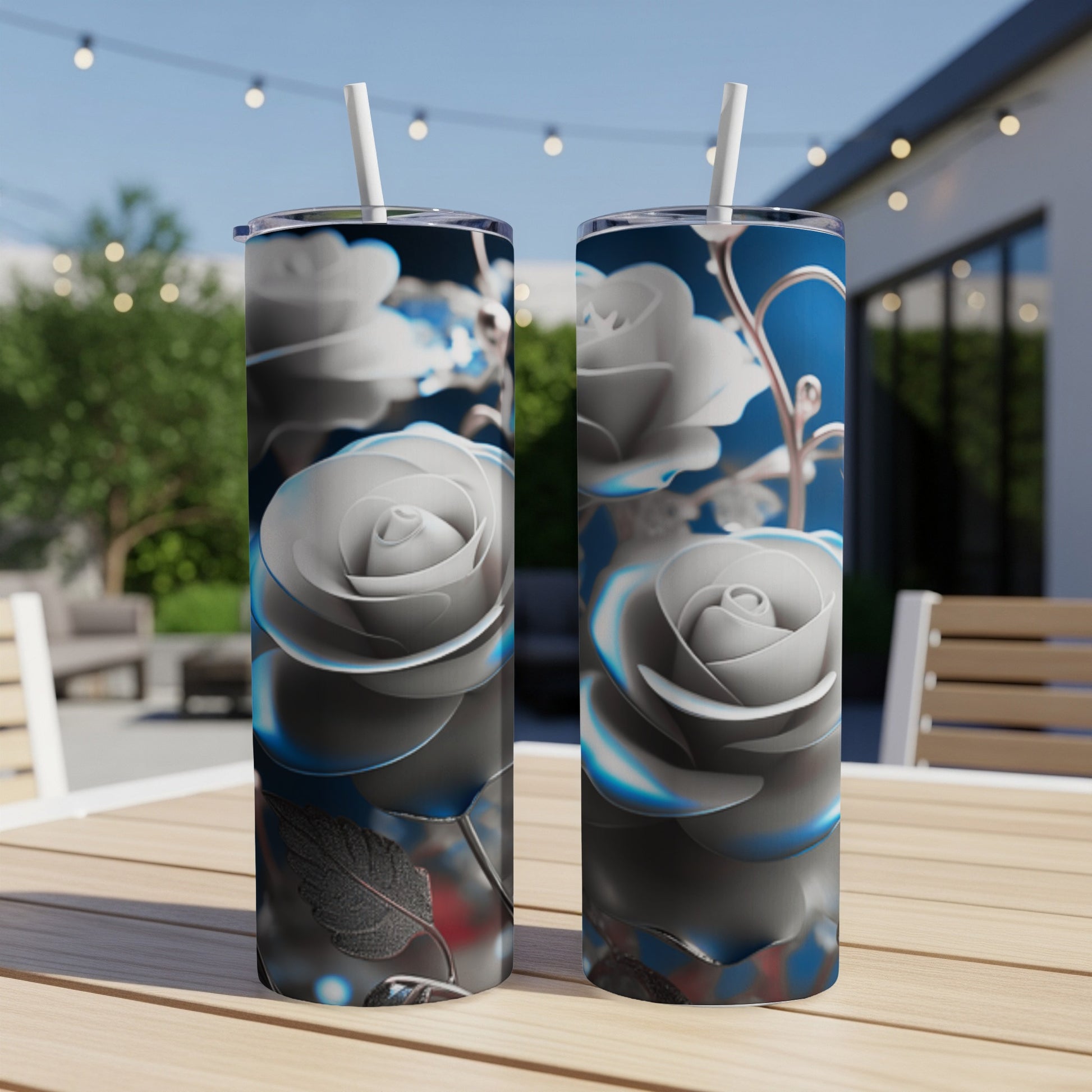 Two tall, slim tumblers with a detailed silver rose design on a table.