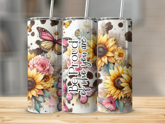 Three tumblers with sunflowers, butterflies, and cow print on a wooden surface.