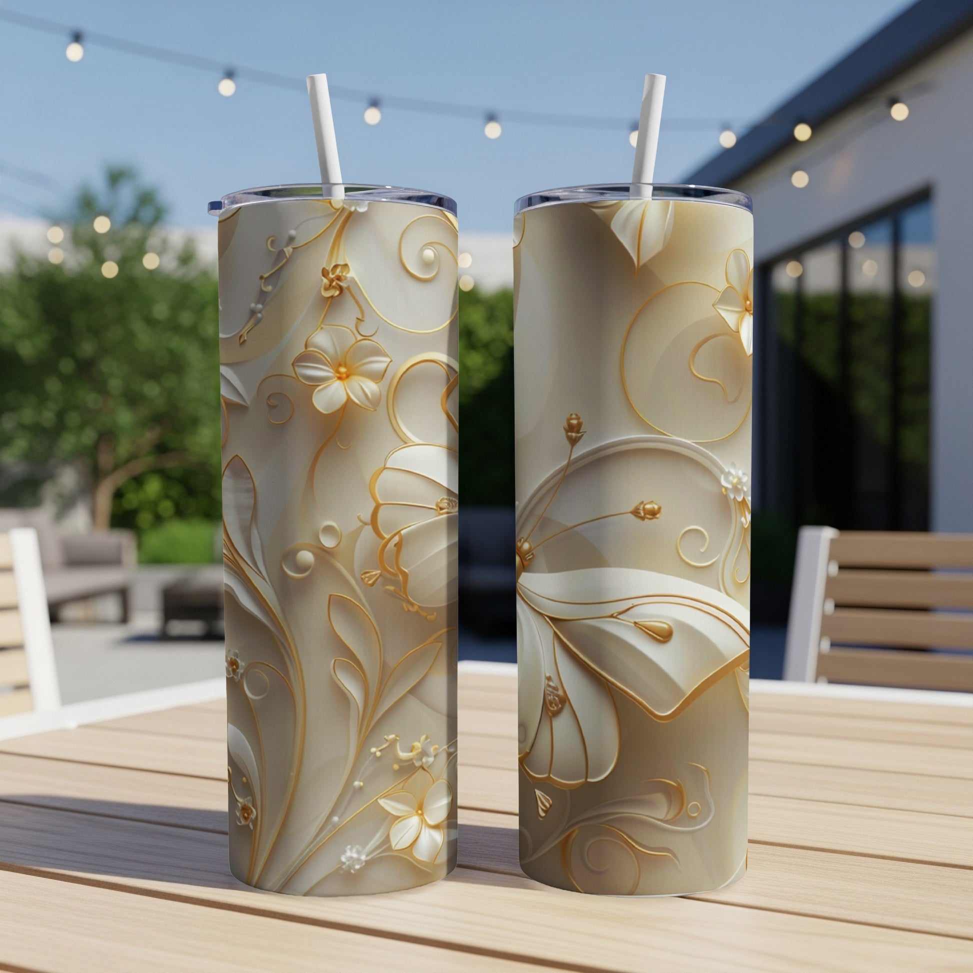 Two tall, slender tumblers with gold floral embossed patterns and straws.