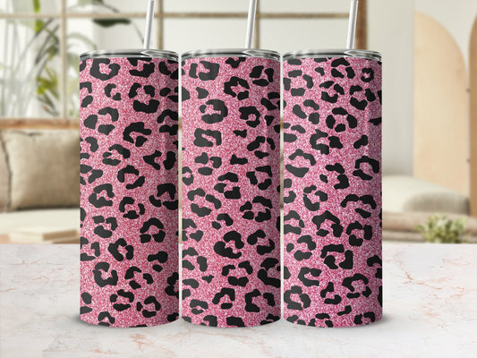 Three pink leopard print tumblers with straws on a marble surface.