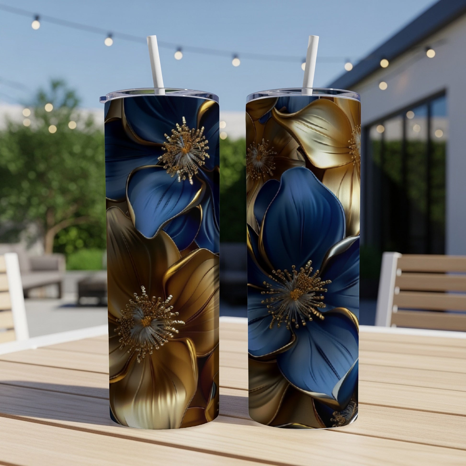 Two blue and gold floral patterned tumblers with straws on a wooden table.