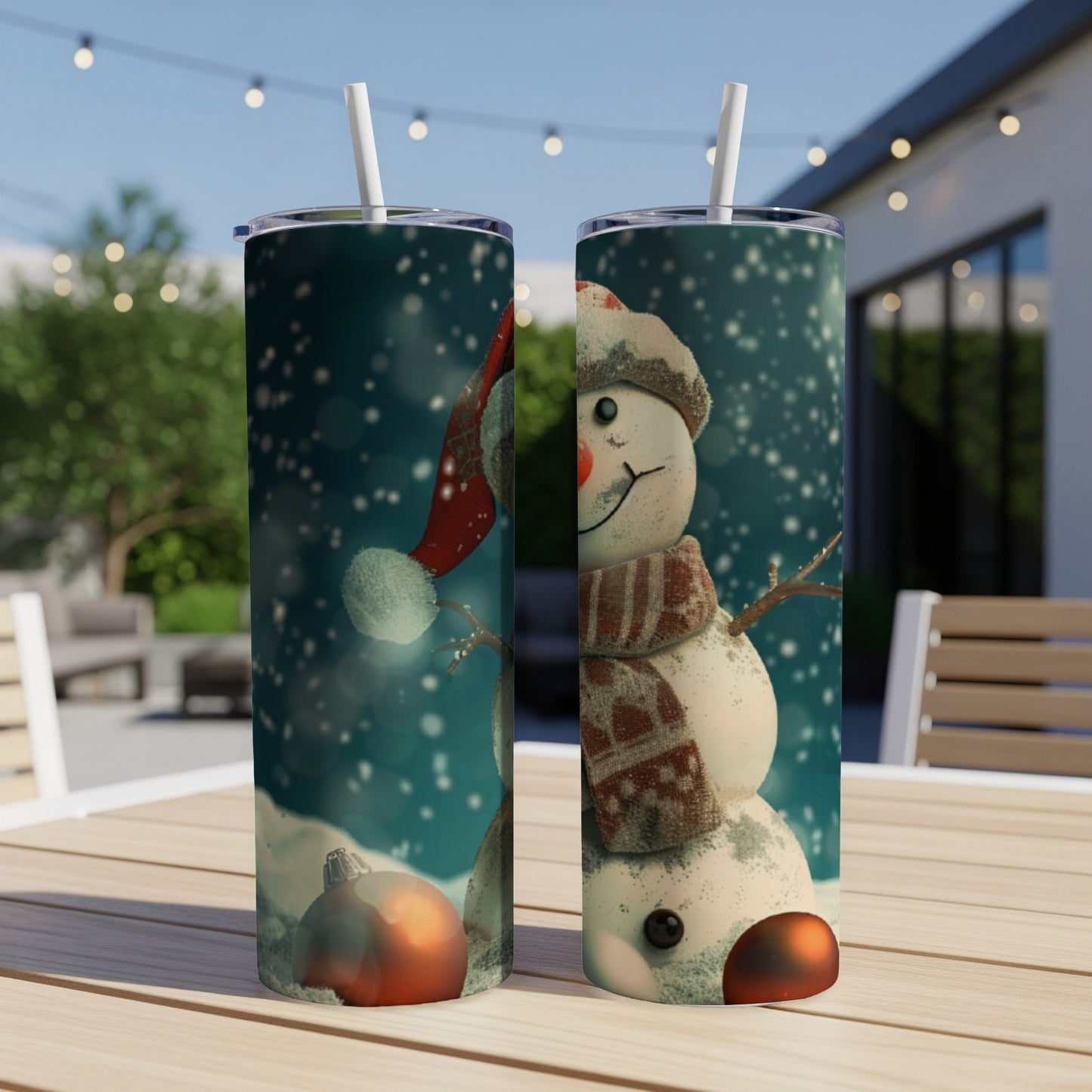 Two tumblers with a festive snowman design sit on a wooden table outdoors.