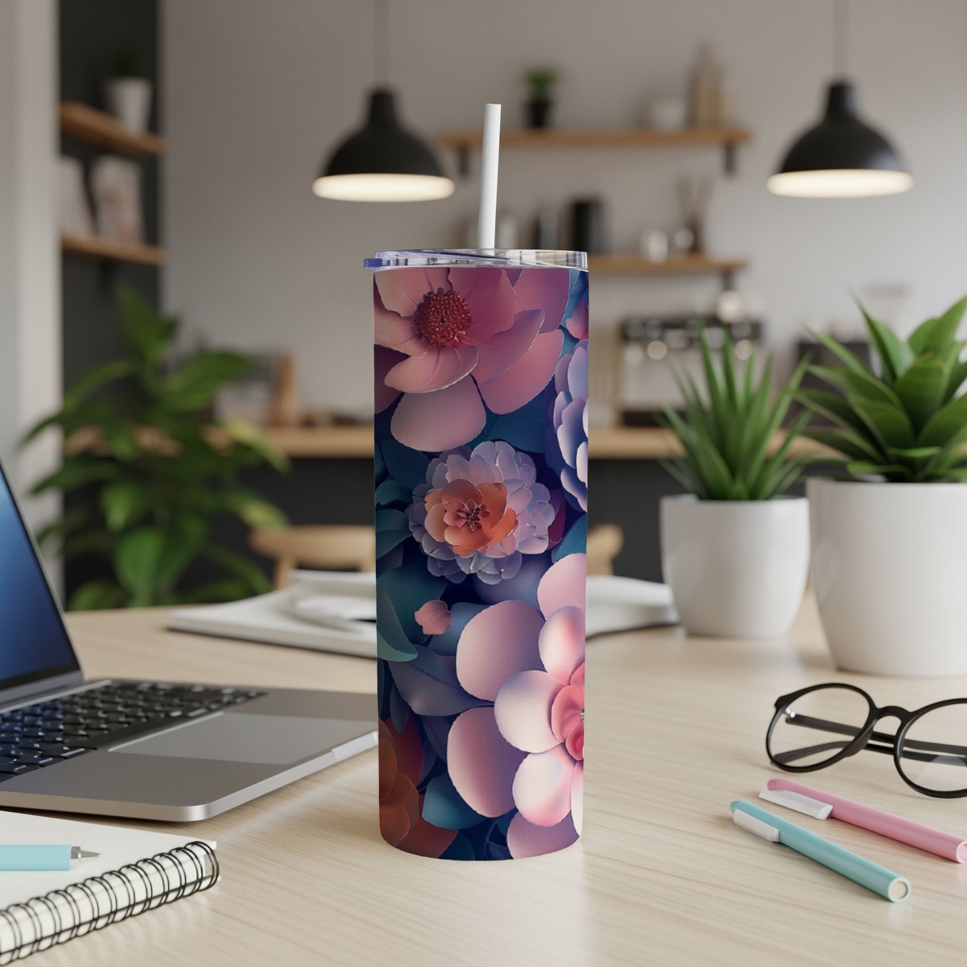Floral patterned tumbler with straw on a desk.