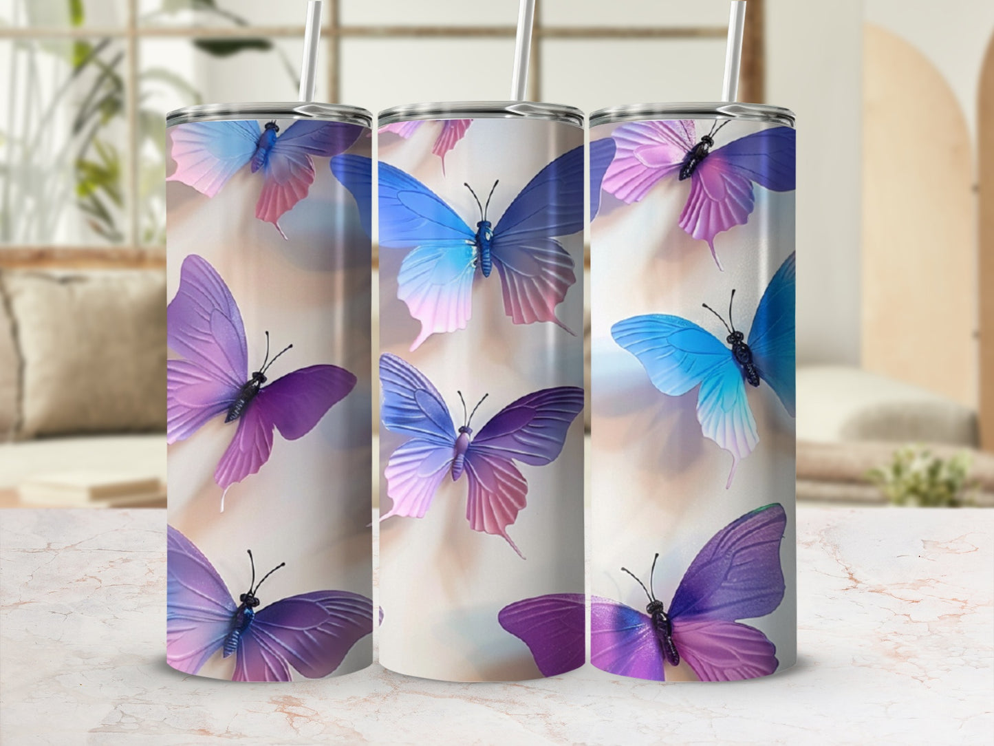 Three tumblers with purple and blue butterfly designs in a soft, blurred background.