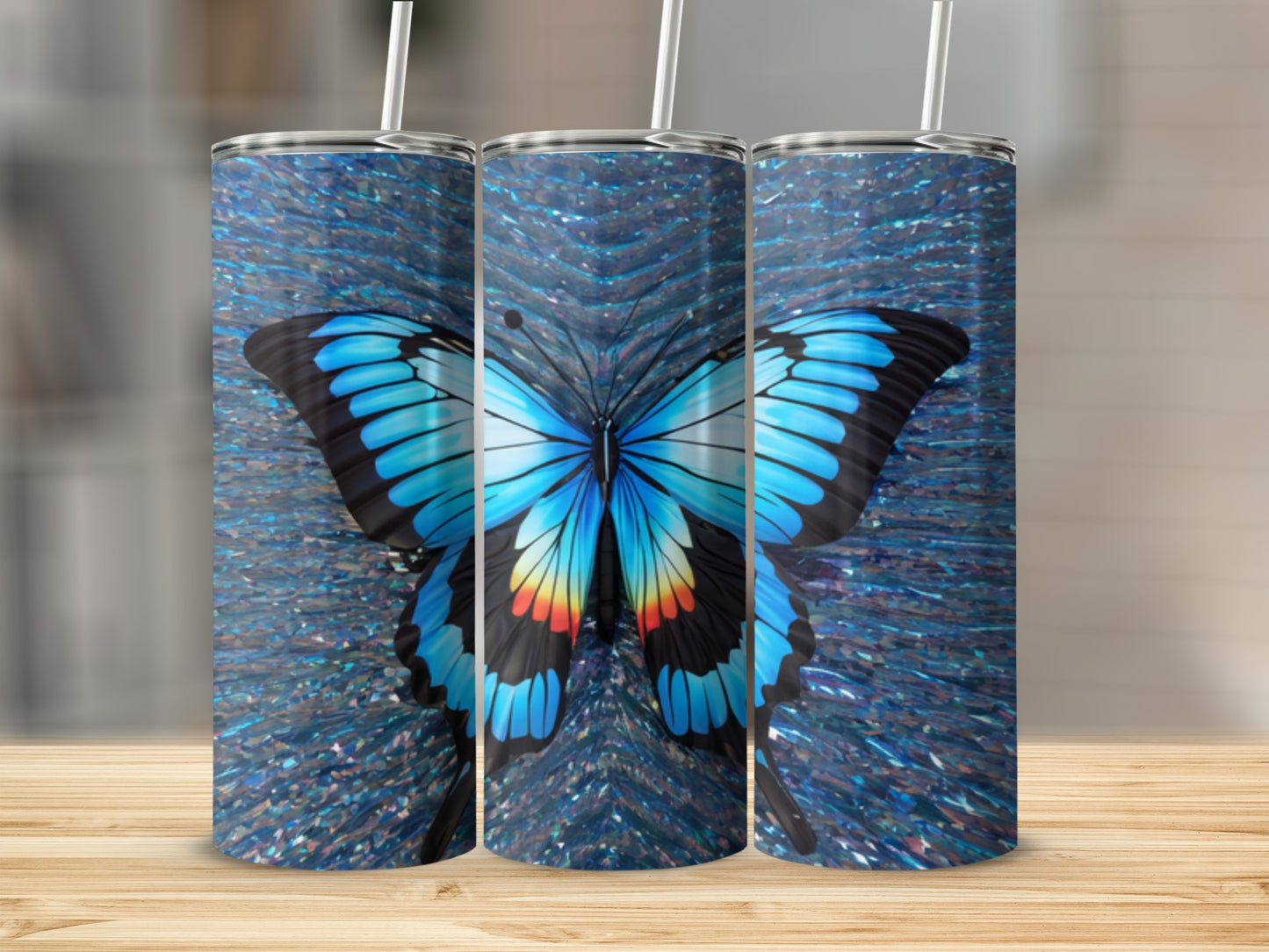 Blue butterfly design on three tumblers with glittery background.