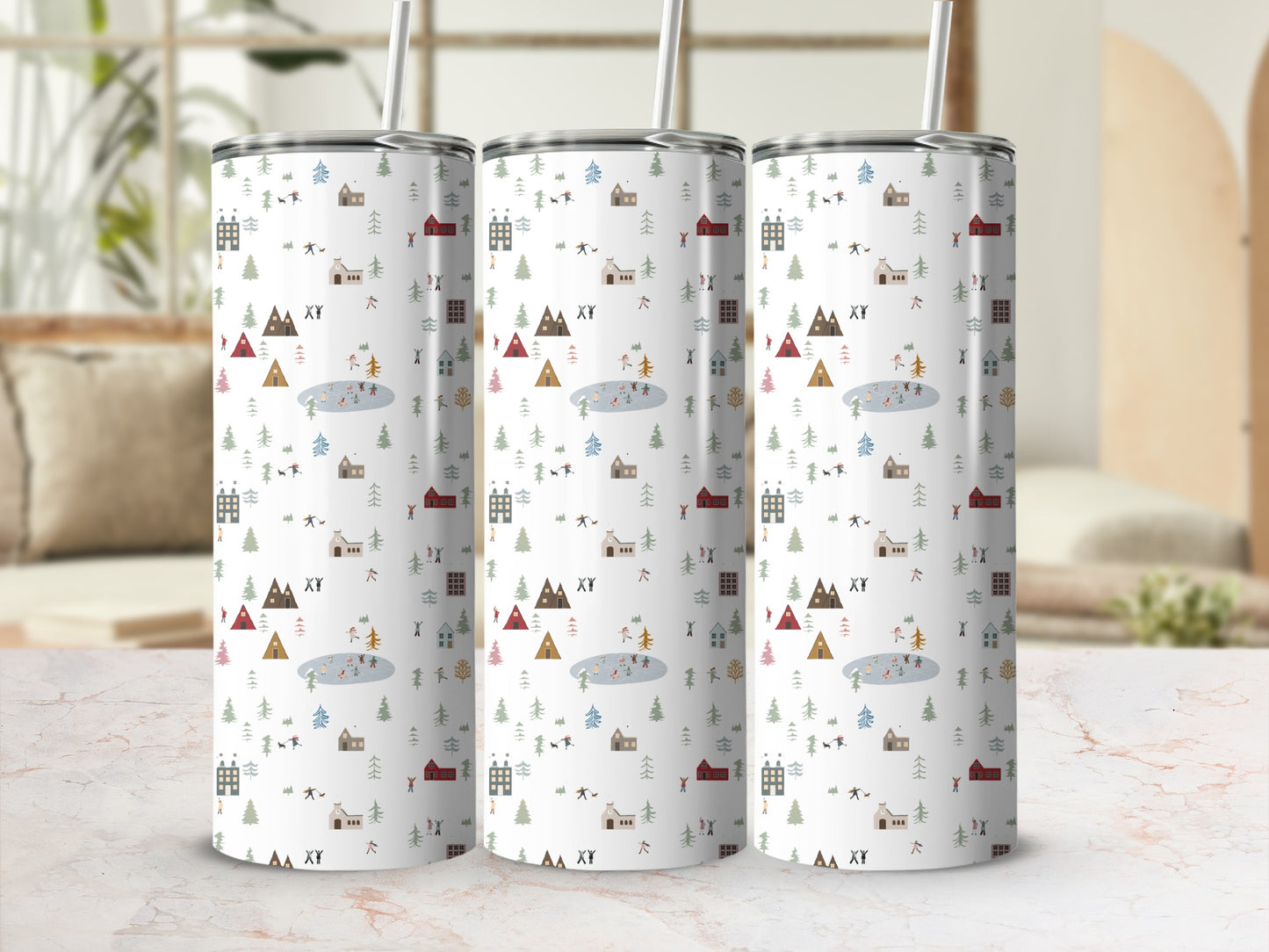 Three tumblers with a winter village scene pattern on a marble surface.