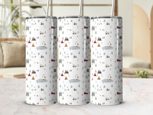 Three tumblers with a winter village scene pattern on a marble surface.