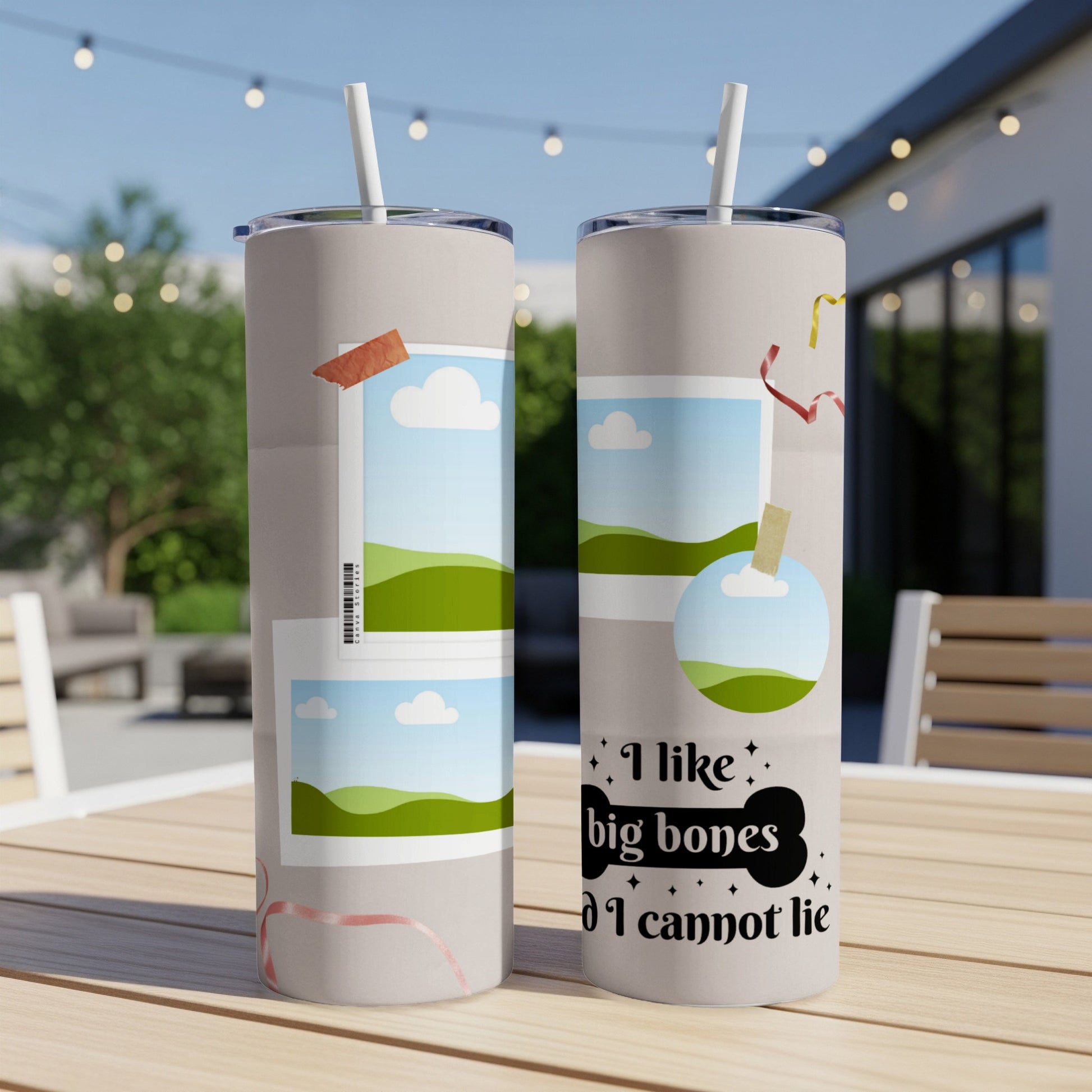 Two tumblers with graphic designs and straws on a wooden table.