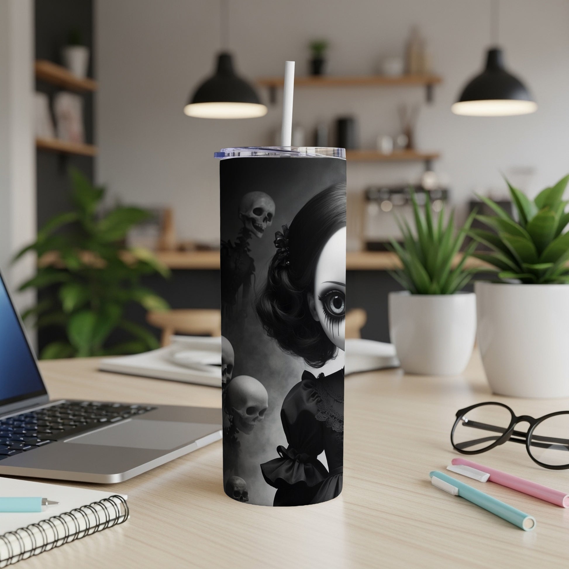 Gothic doll and skulls on a black tumbler with a straw.