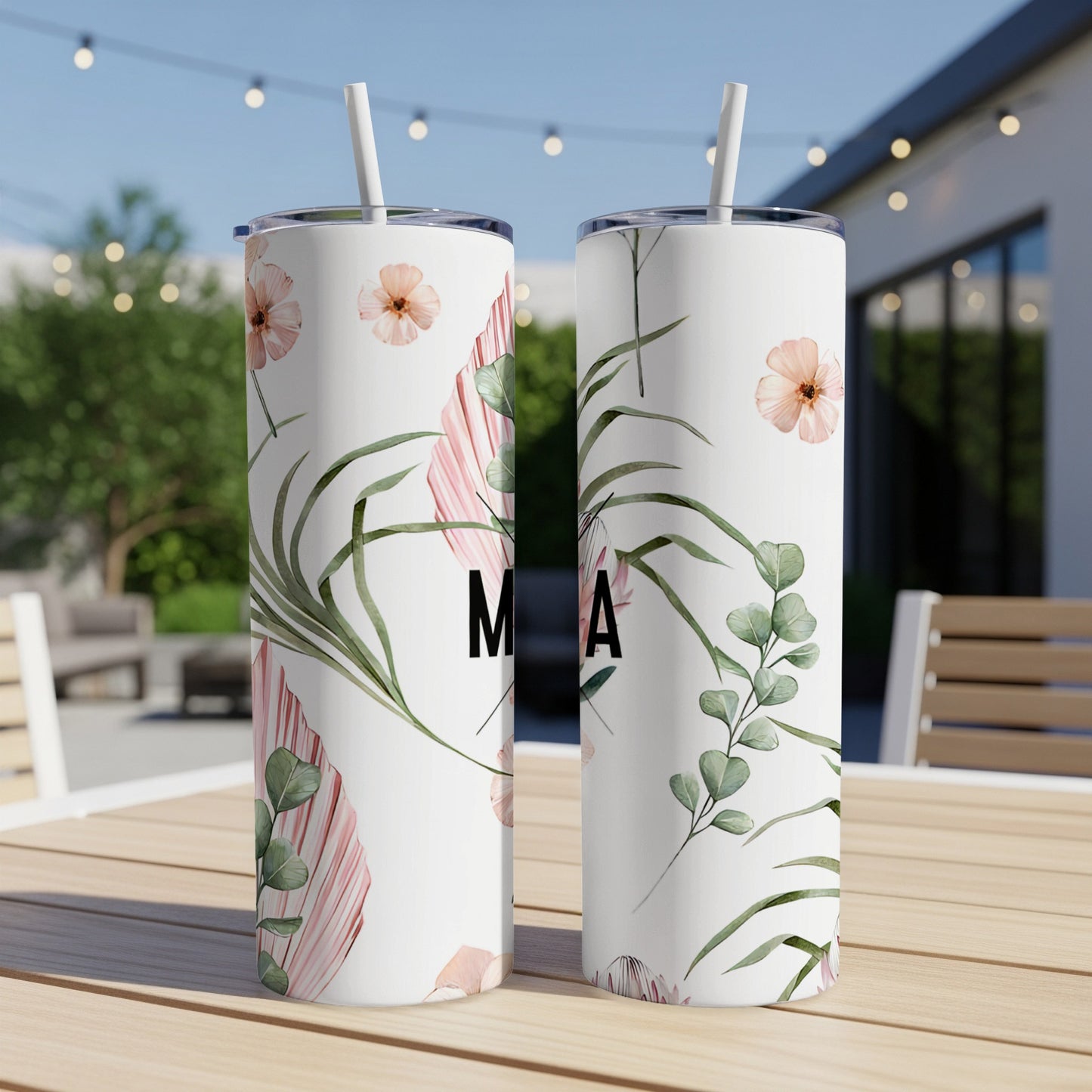 Two white tumblers with floral and leaf pattern and "MA" lettering.