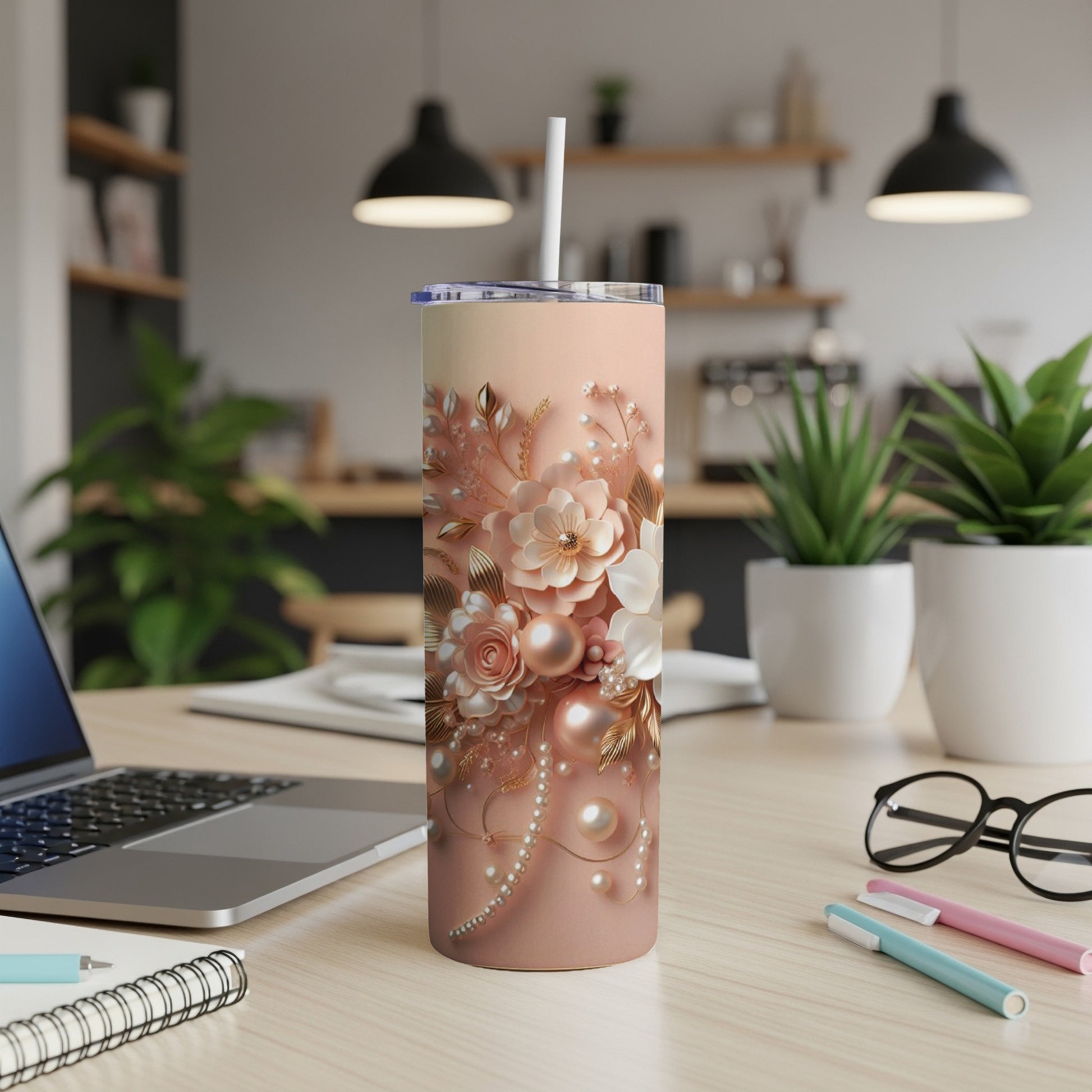 Pink floral tumbler with pearls and gold accents on a desk.