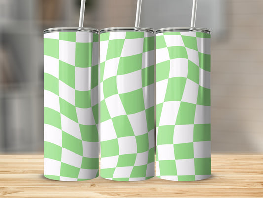Three green and white checkered tumblers with straws on a wooden surface.