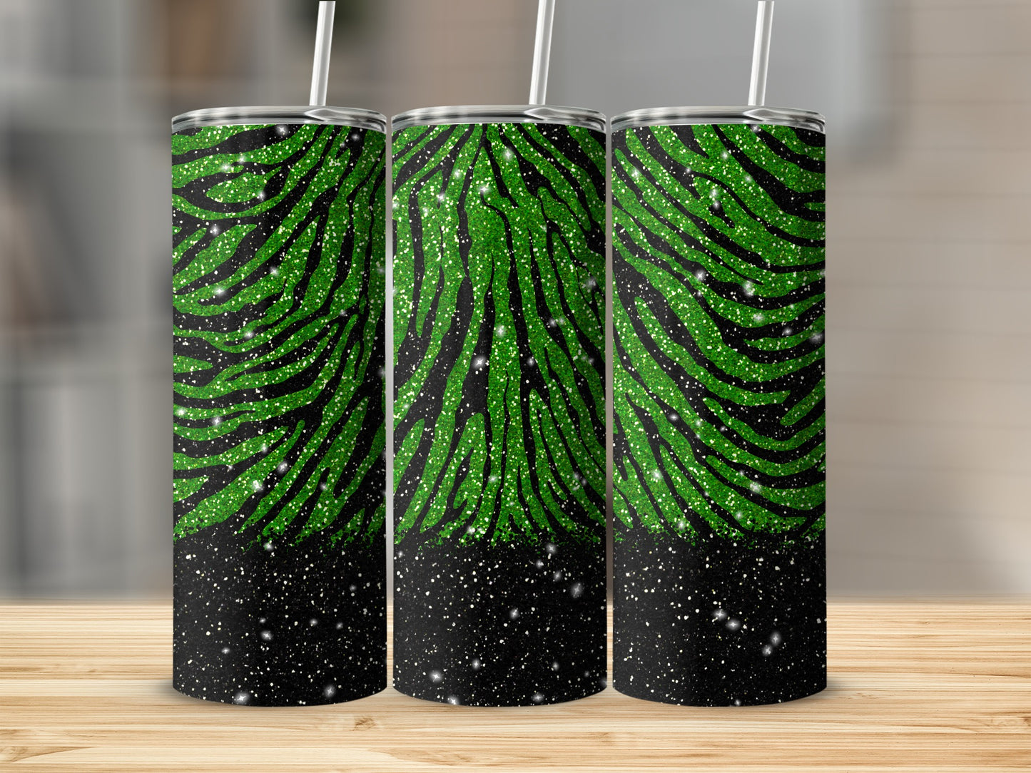 Three green and black striped glitter tumblers on a wooden surface.