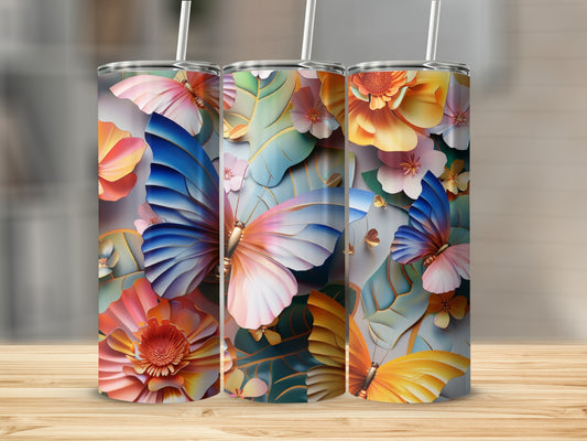 Three tumblers with colorful floral and butterfly designs on a wooden surface.