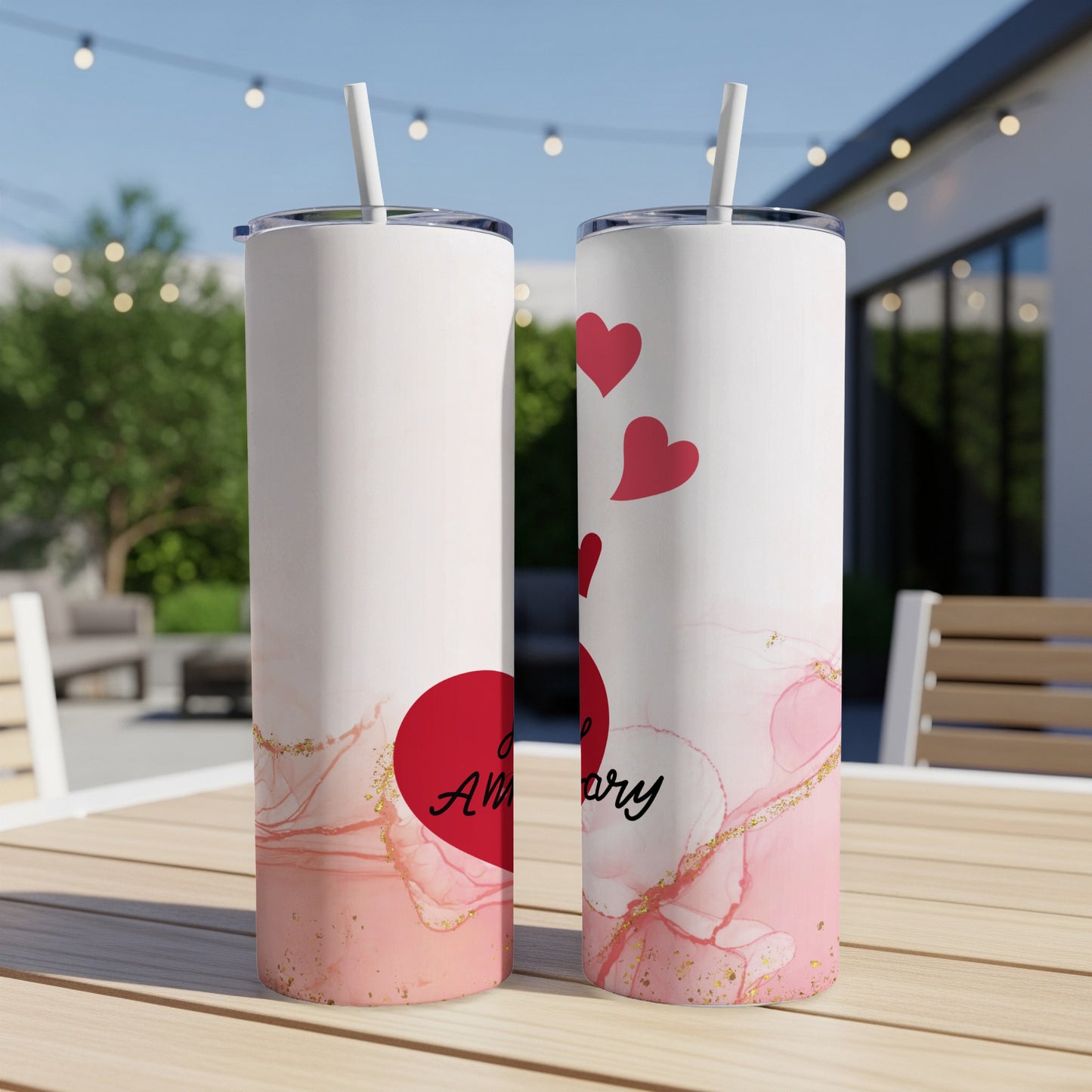 Two white tumblers with red hearts and "Anniversary" text on a table.