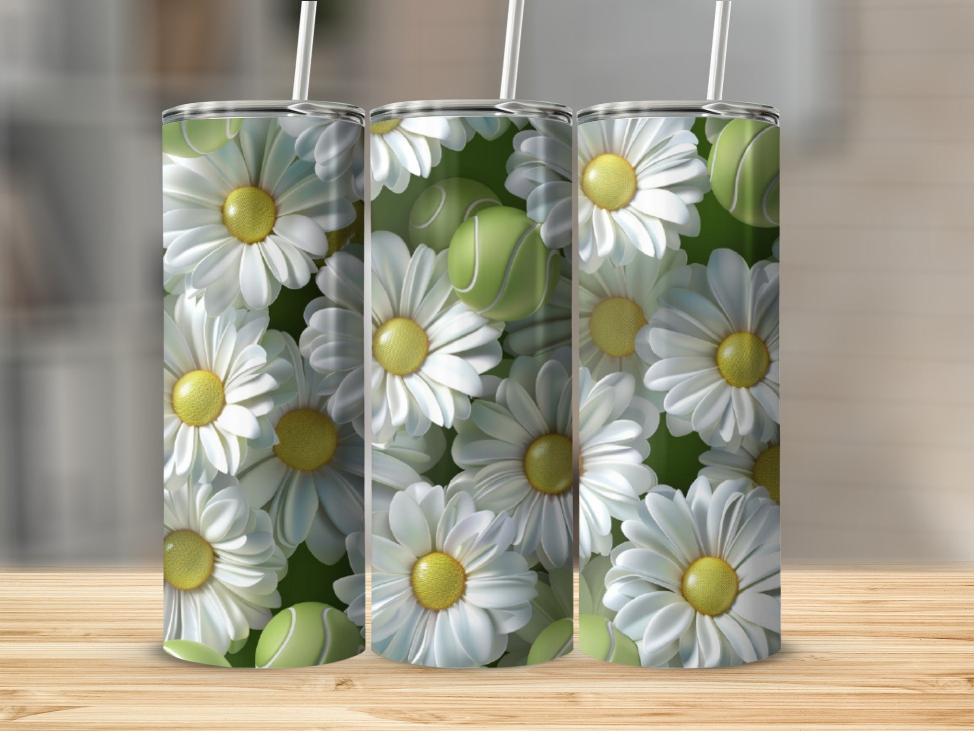 Three tumblers with daisy and tennis ball pattern on wooden surface.