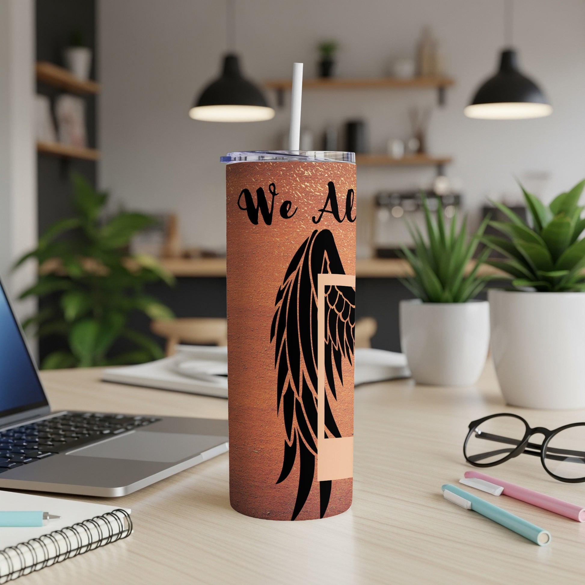 Copper tumbler with black angel wing and "We All" text, white straw.