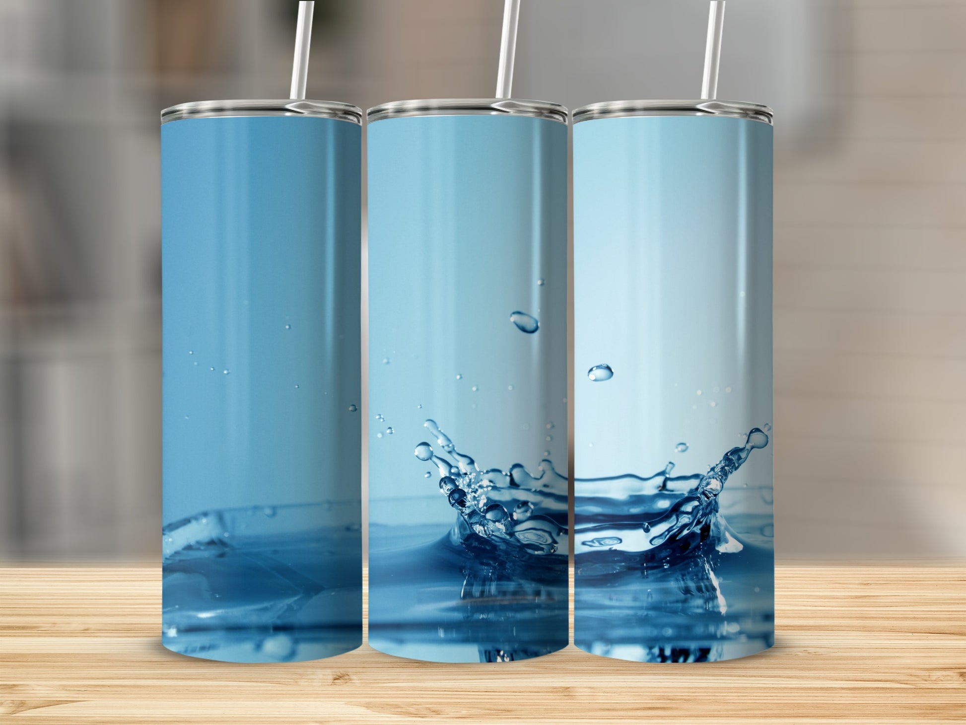 Three tumblers with water splash designs on a wooden surface.