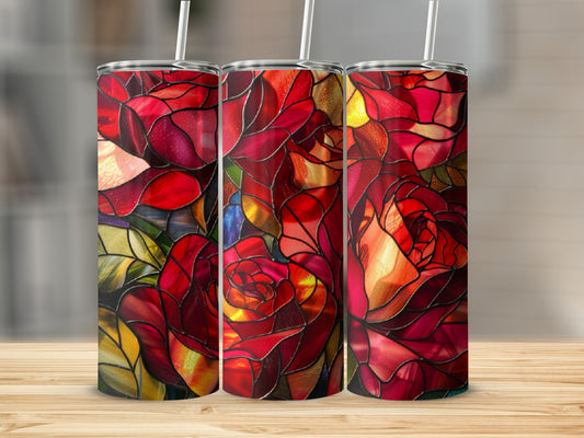 Three tumblers with stained glass rose designs on a wooden surface.