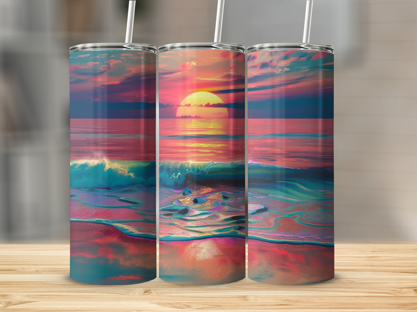 Three tumblers displaying a vibrant sunset over the ocean with crashing waves.