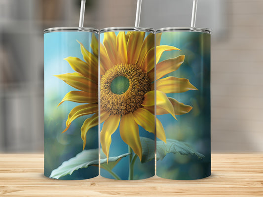 Sunflower tumbler with straw on wooden surface, blurred background.