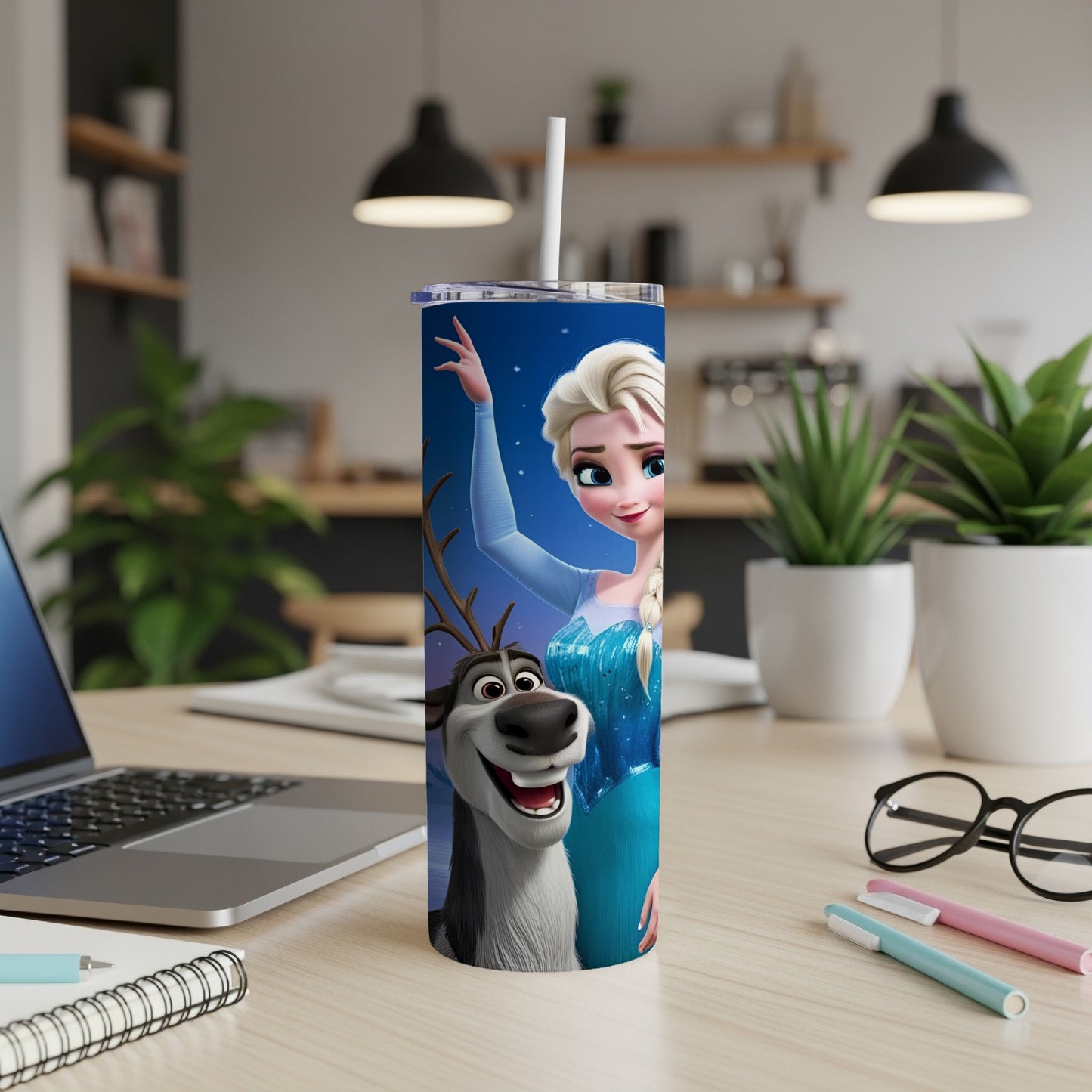 Elsa and Sven from Frozen on a skinny tumbler with a laptop and pens.