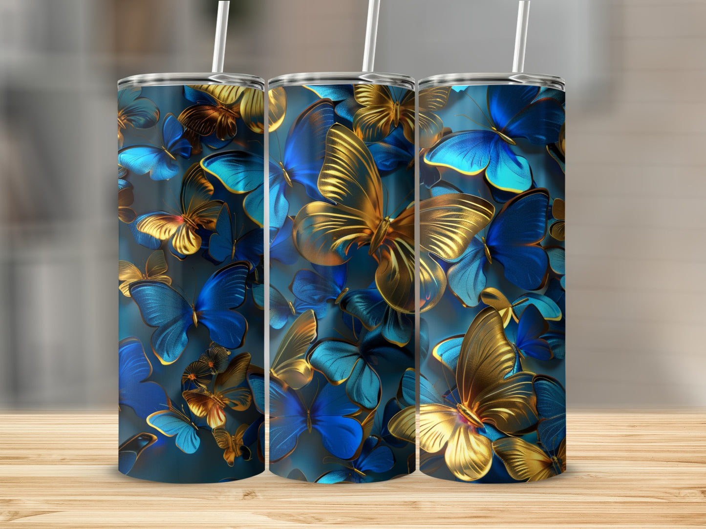 Blue and gold butterflies on three tumblers with straws, on a wooden surface.