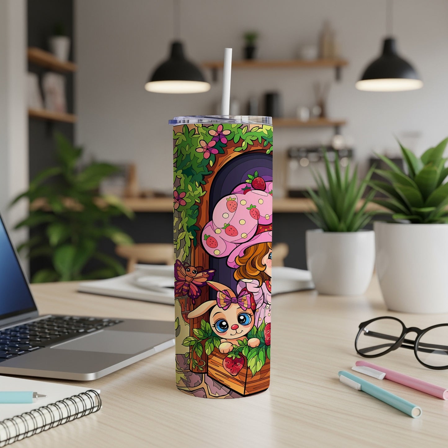 Pink bunny with strawberries and flowers on a tumbler next to a laptop.