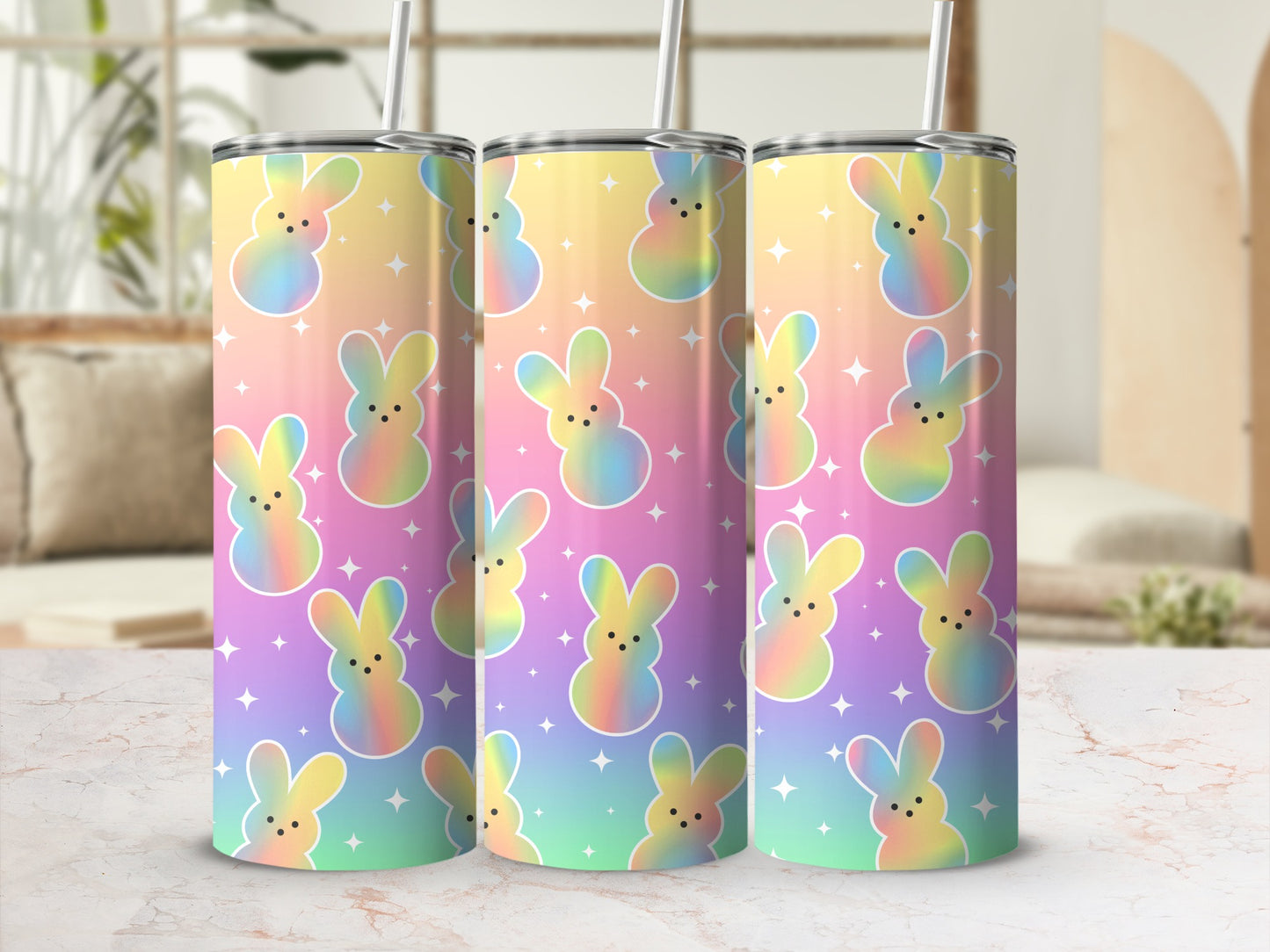 Three pastel rainbow bunny tumblers with stars on a marble countertop.